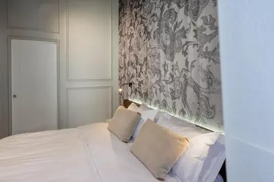 a bedroom with a white bed with a patterned wall at Dreamers in Belsiana Spagna int 8 in Rome