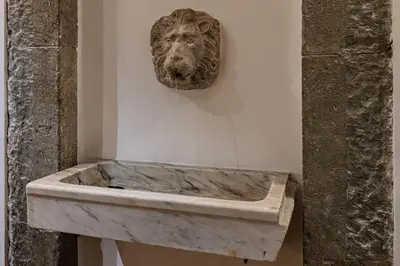 a statue of a lion on a wall in a museum at Domus Campo de Fiori in Rome