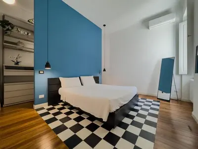 a bedroom with a bed with a blue wall and a checkered floor at Casa Alessandria in Rome