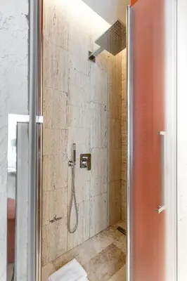 a shower with a shower head in a bathroom at Petra Apartments San Giovanni in Rome