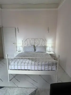 a white bed in a white bedroom with two lamps at BANGA HOUSe in Rome