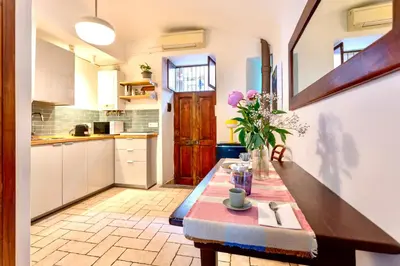 a kitchen with a table with a vase of flowers at San Lorenzo Studio Flat in Rome