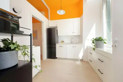 a kitchen with white cabinets and an orange ceiling at Elegance in Parioli Rome La casa di Pigi in Rome