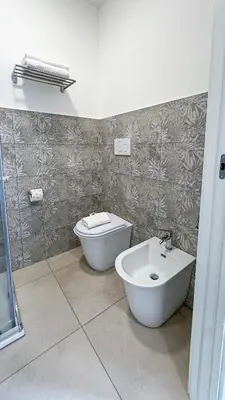 a bedroom with a bed with a painting on the wall at GuestHouse Denina67 - ChiacchioPM in Rome