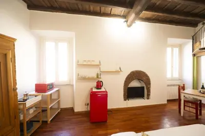 a room with a red refrigerator in the middle of a room at Trastevere Romantic Nest in Rome