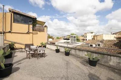 a patio with a table and chairs on a building at Trastevere Romantic Nest in Rome