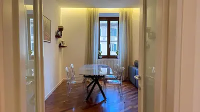 a dining room with a glass table and chairs at Elegant Roman Escape Walk to the Colosseum in Rome