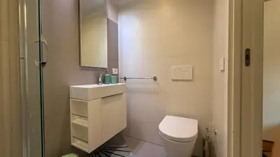 a white bathroom with a toilet and a sink at Elegant Roman Escape Walk to the Colosseum in Rome