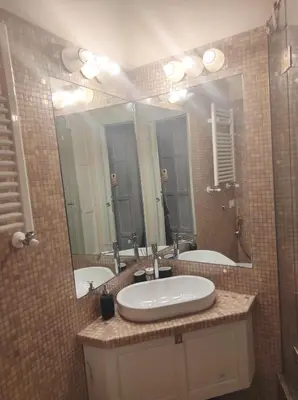 a bathroom with two sinks and a large mirror at Library's House in Rome
