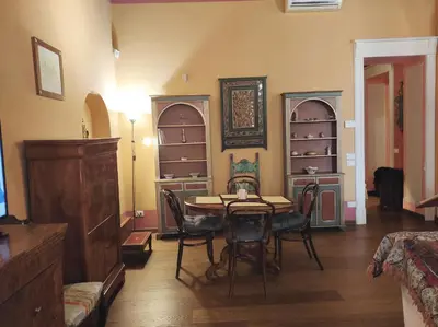 a dining room with a table and chairs and shelves at Library's House in Rome