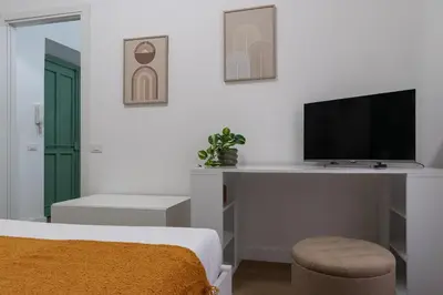a bedroom with a bed and a tv on a desk at City Comfort - 20 minutes walk to the Colosseum in Rome