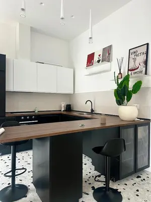 a kitchen with a wooden counter and black chairs at Casa Conce two metro stops from the colosseum in Rome