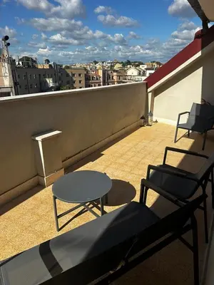 a balcony with two chairs and a table on a roof at Casa Conce two metro stops from the colosseum in Rome