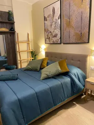 a bed with blue sheets and pillows in a room at Gentile RHome Apartment, casa vacanze in Rome