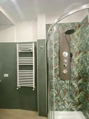 a shower in a bathroom with a green wall at Gentile RHome Apartment, casa vacanze in Rome