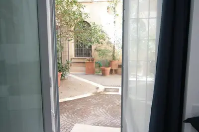 an open door with a view of a courtyard at 1886 Colosseo Suite in Rome