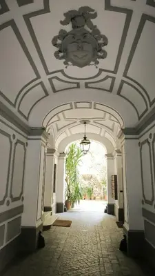 an empty hallway with a ceiling with a chandelier at 1886 Colosseo Suite in Rome