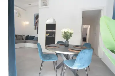a dining room with a table and blue chairs at 1886 Colosseo Suite in Rome