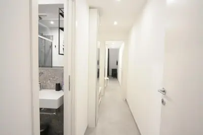 a white bathroom with a sink and a mirror at 1886 Colosseo Suite in Rome