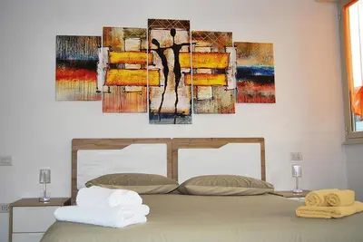 a bedroom with a bed with a painting on the wall at Tiburtina Family Apartment in Rome