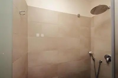 a bathroom with a shower with beige tile at Roma Suite Loft in Rome