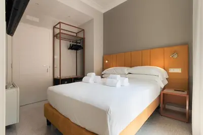 a bedroom with a large white bed with a wooden headboard at Velia Relais in Rome