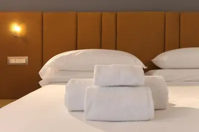a pile of towels sitting on top of a bed at Velia Relais in Rome