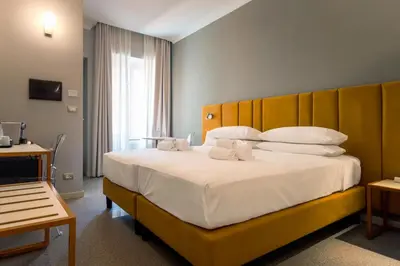 a bedroom with a large white bed with a wooden headboard at Velia Relais in Rome