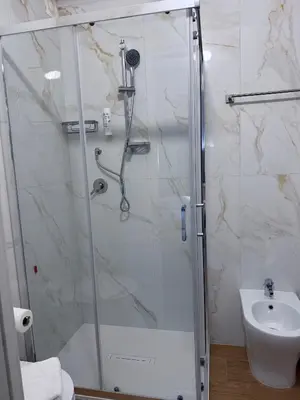 a bathroom with a shower with a toilet and a sink at Tiburtina Hotel Holiday in Rome