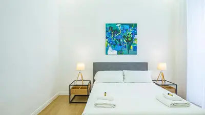 a bedroom with a bed with two lamps and a painting at Domus Re di Roma Design Suite in Rome