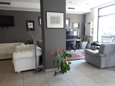 a living room with a couch and chairs and a television at Hotel Aniene in Rome