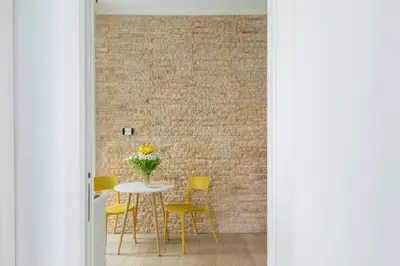 a dining room with a table and yellow chairs at iFlat Vatican Modern & Comfortable Peaceful Gem in Rome