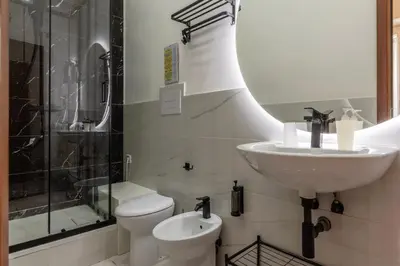 a bathroom with a sink and a toilet and a shower at GuestHost - Metro Cipro-Ottaviano Apartment X6 in Rome