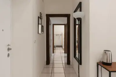 a hallway with white walls and a floor with a mirror at GuestHost - Metro Cipro-Ottaviano Apartment X6 in Rome