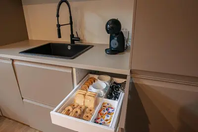 a kitchen and a living room with a table and chairs at Pied-à-terre Ponte Milvio in Rome