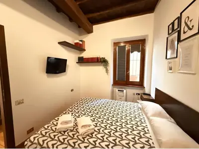 a bedroom with a bed with two chairs on it at Pantheon Private Apartment in Rome
