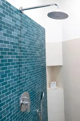 a blue tiled bathroom with a shower and a toilet at Licia House - Intero Appartamento - San Giovanni in Rome