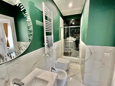 a green bathroom with a sink and a toilet at Casa Vacanze Jenner in Rome