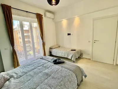 a bedroom with two beds and a large window at Casa Vacanze Jenner in Rome