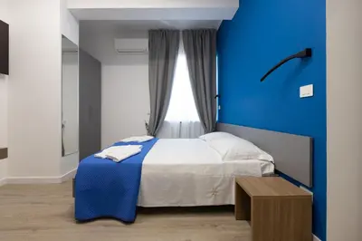 a blue bedroom with a bed and a blue wall at Suemy Rome B&B in Rome