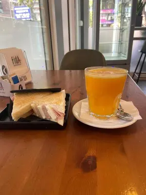 a sandwich and a drink on a plate on a table at Suemy Rome B&B in Rome