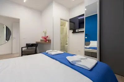 a bedroom with a large white bed with blue sheets at Suemy Rome B&B in Rome