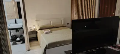 a small bedroom with a bed and a television at Studio Flat Rome Metro Garbatella in Rome