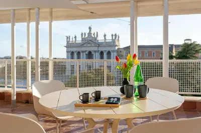 a white table on a balcony with a view of a building at San Giovanni Rooftop in Rome