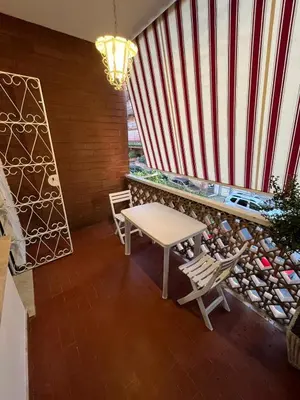 a table and chairs in a room with a large window at Alloggio Turistico Perez Martinez Maria Petronila in Rome
