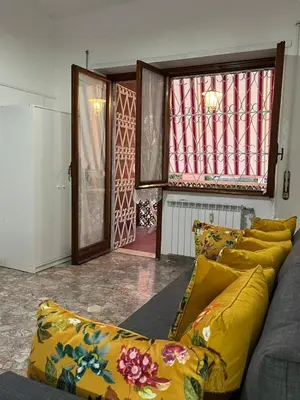 a living room with a couch with yellow pillows at Alloggio Turistico Perez Martinez Maria Petronila in Rome