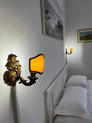a lamp on a wall next to a bed at Alloggio Turistico Perez Martinez Maria Petronila in Rome