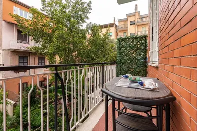 a balcony with a wooden table and chairs on a building at Comfort House in Rome