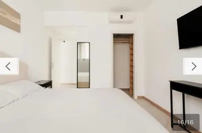 a bedroom with a white bed and a television at Trastevere City Life Apartments in Rome