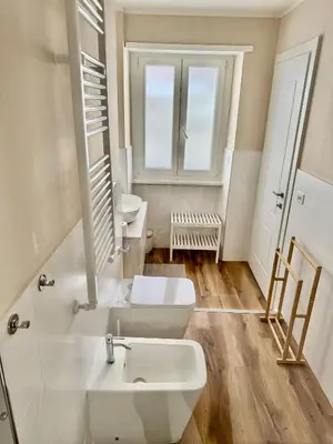 a white bathroom with two sinks and a window at Domus Antea in Rome